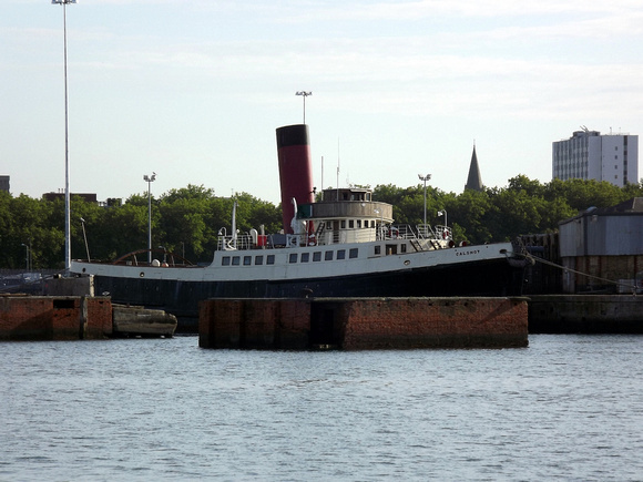 The preserved tug Calshot is moored in front of Queen Mary 2